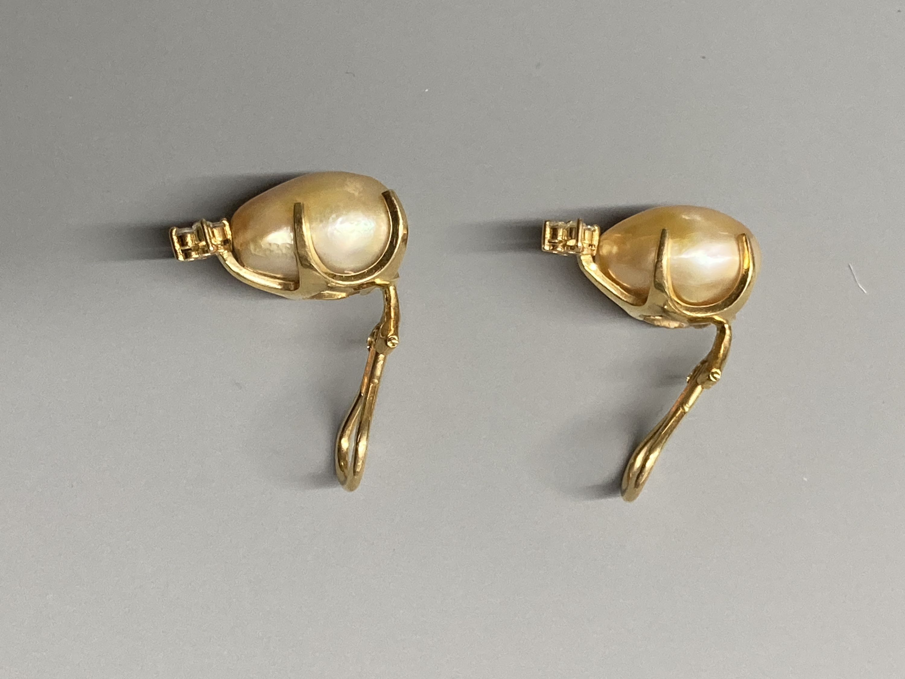 A modern pair of 18k yellow metal, baroque pearl and four stone diamond chip set ear clips, 21mm, gross 9.7 grams.